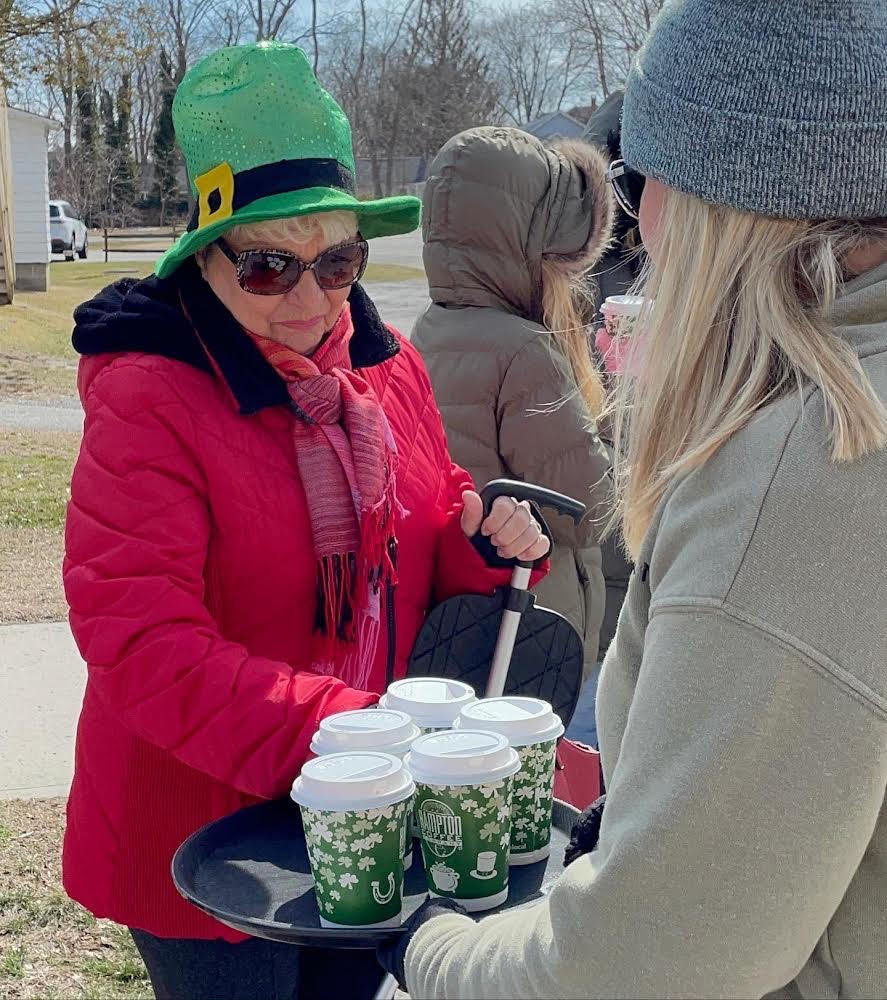 Theresa Belkin, co-owner of Hampton Coffee Company, passes out coffee at the St. Patrick’s parade on Main Street in Center Moriches.